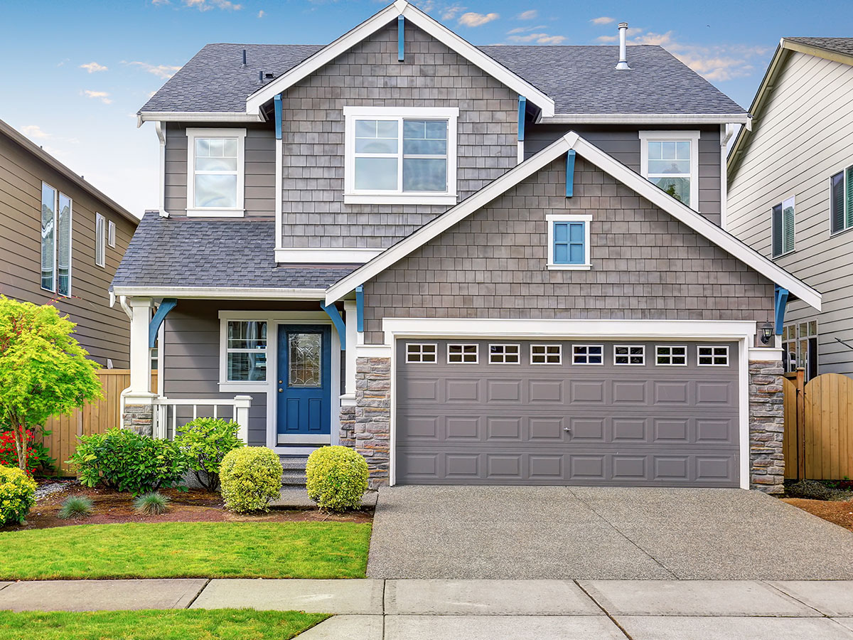 A house with green bushes in the front yard