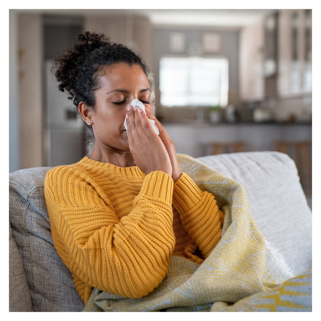 a woman blowing her nose in her apartment