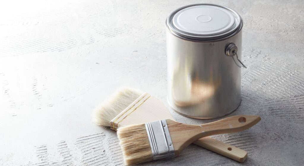 a can of paint and paint brushes