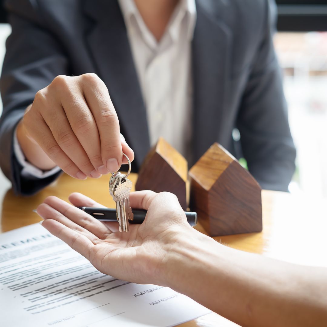 real estate agent handing key to new homeowner